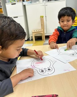 Children at Level Up Montessori coloring to build confidence and early academic skills for kindergarten readiness.