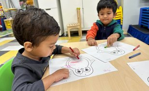 Children at Level Up Montessori coloring to build confidence and early academic skills for kindergarten readiness.
