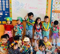 Children in Hawaiian outfits at Level Up Montessori enhancing confidence and early academic skills.