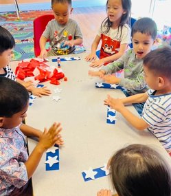Toddlers at Level Up Montessori engaged in a hands-on learning activity around a table.
