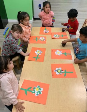 Preschool children at Level Up Montessori engaged in a hands-on flower craft activity, fostering early learning and creativity.