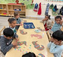 Children engaging in a colorful Montessori activity at a table, enhancing learning and creativity.