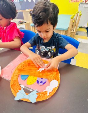 Child engaging in a Montessori craft activity, enhancing confidence and early academic skills for kindergarten readiness.