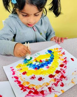 Toddler engaged in painting at Level Up Montessori, enhancing early skills through hands-on learning and play.