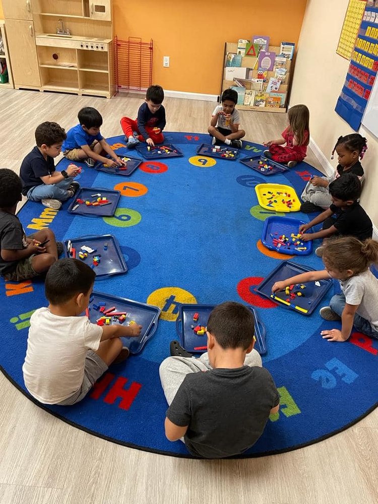 Children engaging in hands-on learning at Level Up Montessori preschool, sitting in a circle working on academic activities.