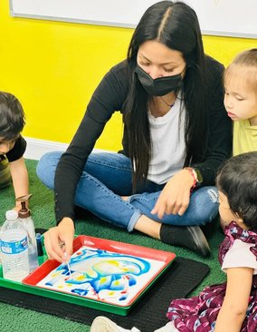 Teacher engaging children in a creative activity at Level Up Montessori in the Bay Area.
