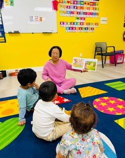 Teacher engaging children in a colorful Montessori classroom at a Bay Area center.