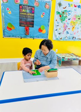 Teacher and child engaged in learning activity at Level Up Montessori, showcasing supportive team culture.