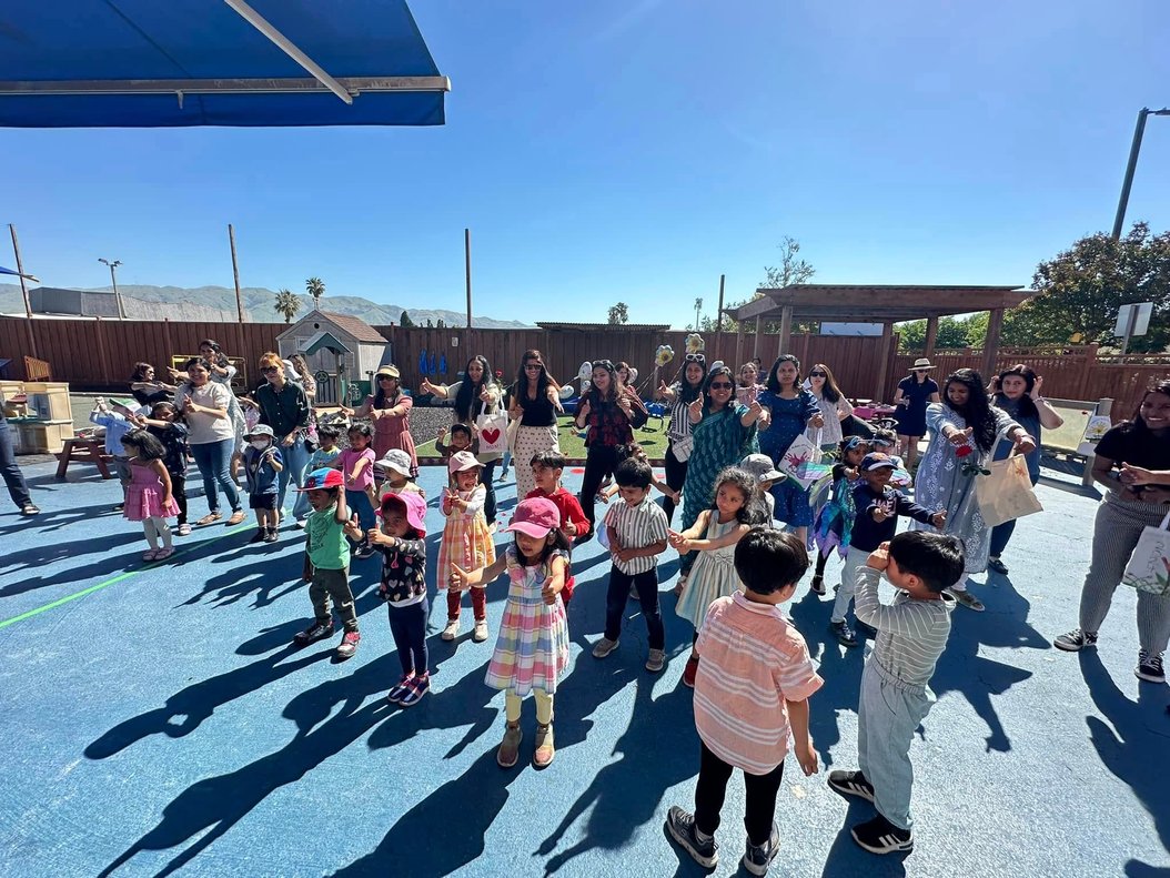 Children and adults participating in an outdoor Montessori learning activity to support confidence and kindergarten readiness.