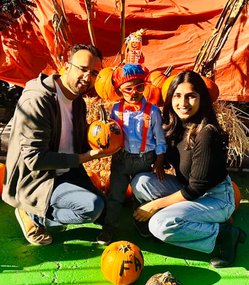 Family engaged in hands-on learning with pumpkins at Level Up Montessori's creative project event.