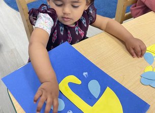 Infant engaged in creative art activity at Level Up Montessori, nurturing early growth and discovery.