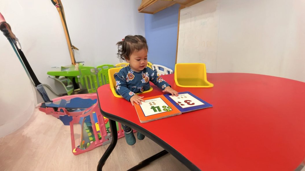 Infant learning at Level Up Montessori Bay Area location with colorful books.