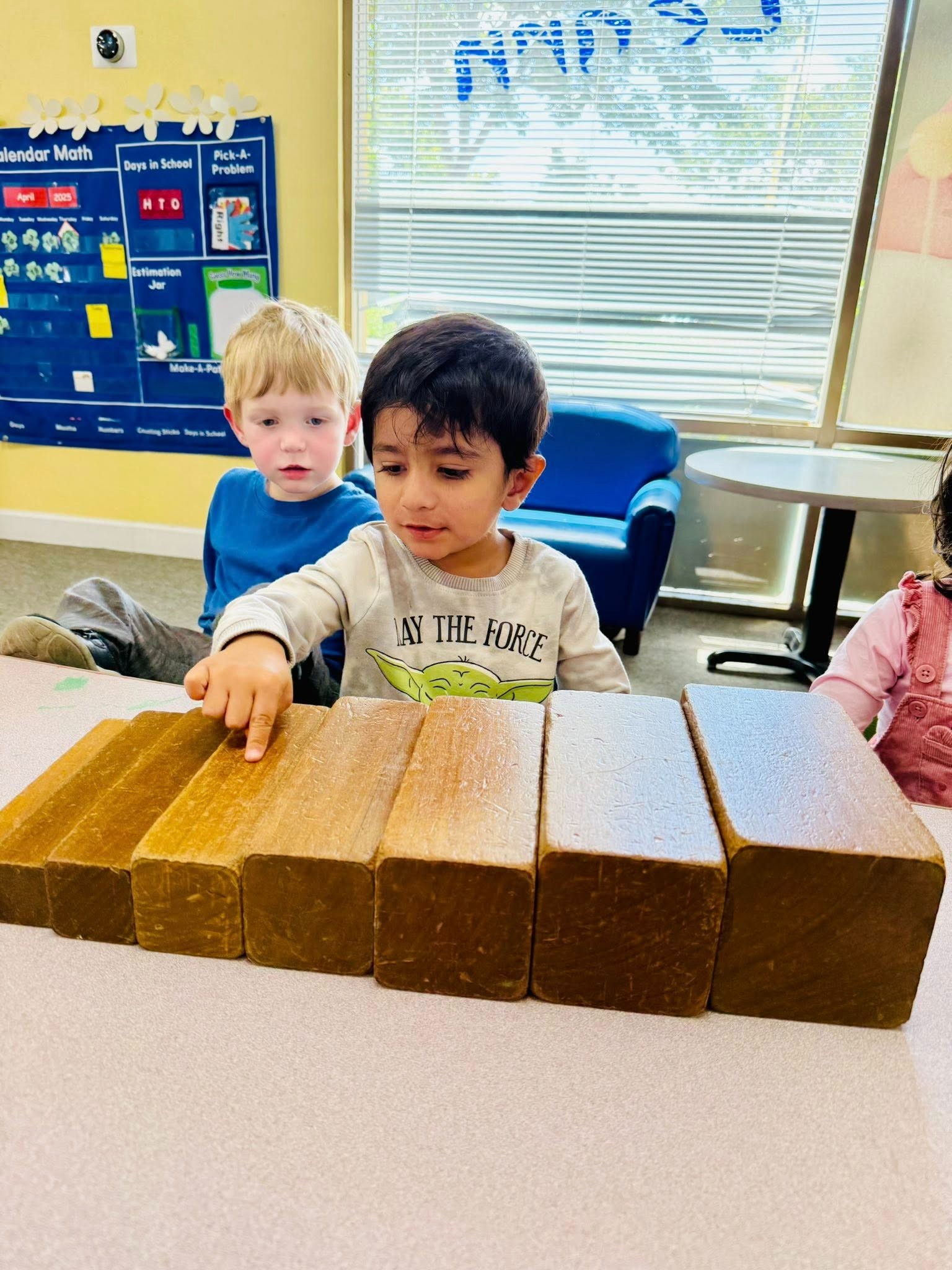 Preschool children at Level Up Montessori engaging in hands-on learning with wooden blocks.