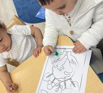 Infants exploring coloring activity at Level Up Montessori, fostering early growth and discovery in a nurturing environment.