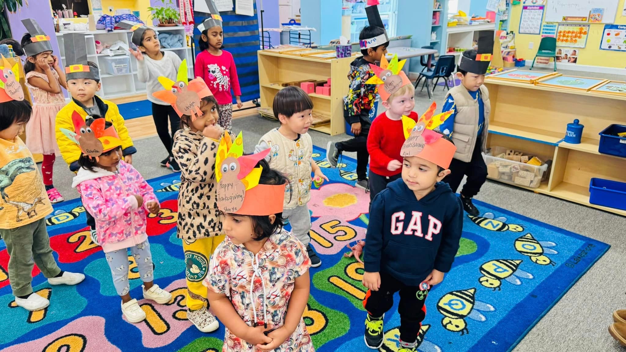 Toddlers at Level Up Montessori enjoying hands-on learning and play, wearing festive arts and crafts hats.