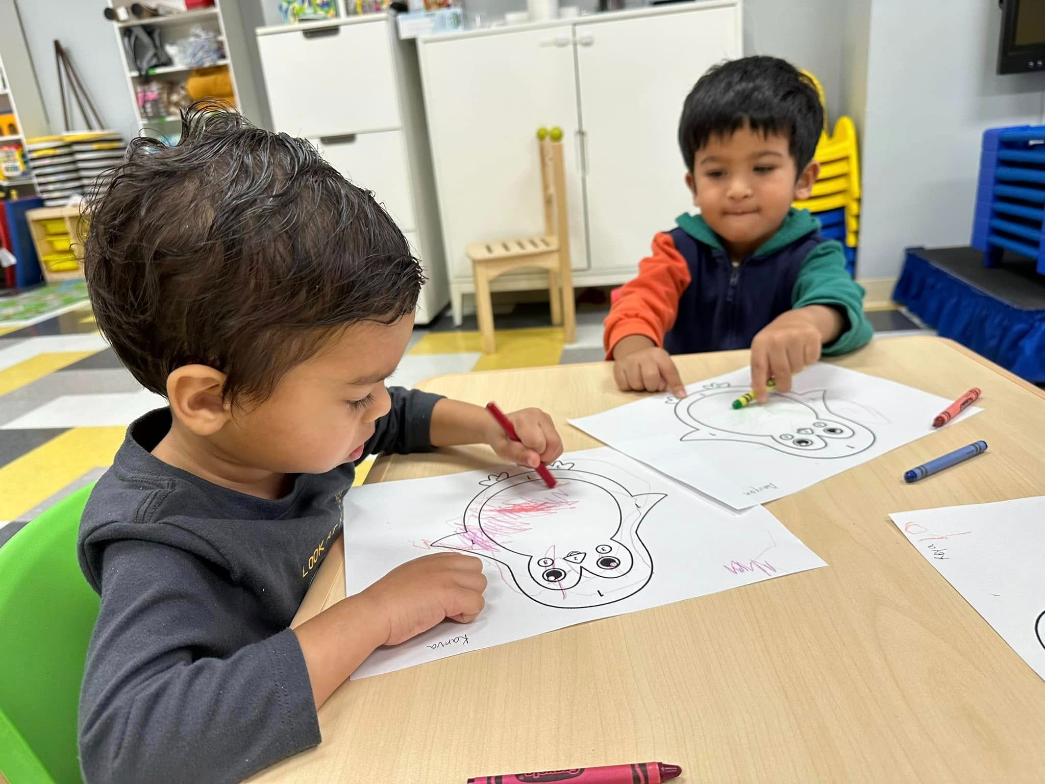 Children at Level Up Montessori coloring to build confidence and early academic skills for kindergarten readiness.